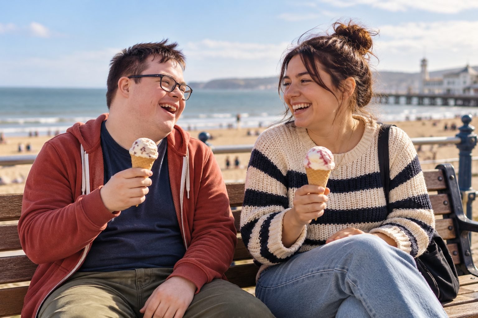 Two young people eating ice cream by the sea