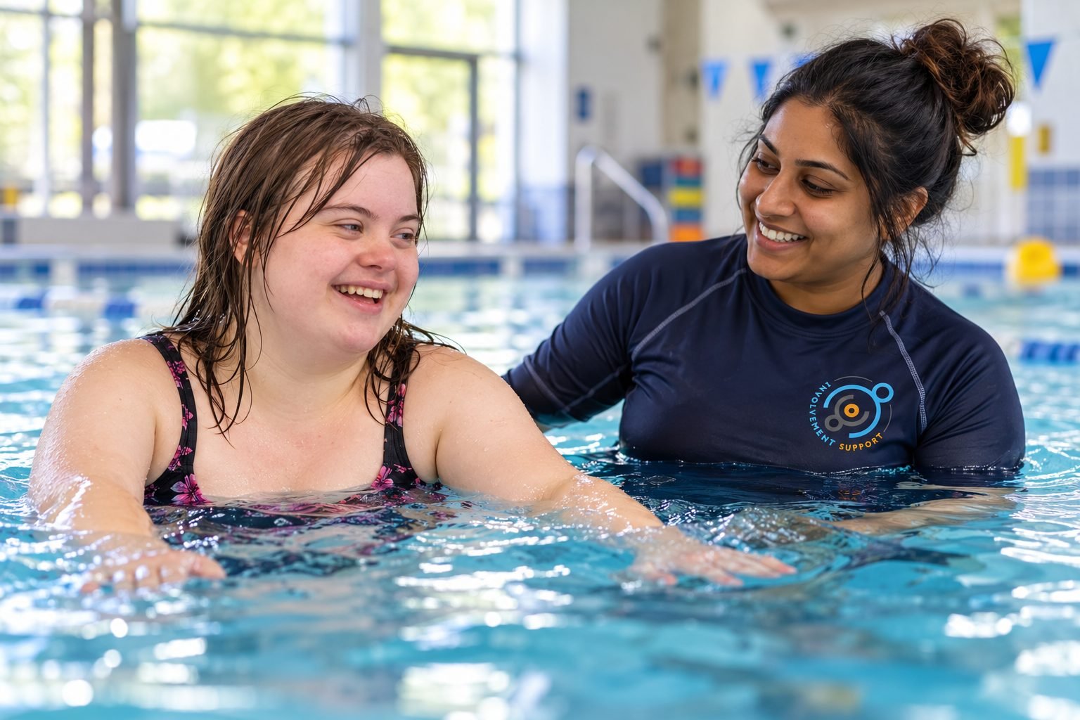A young woman swimming with her support worker